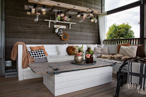 Seating area on terrace with wooden furniture and fairy lights