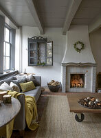 Living room with fireplace, grey sofa and wooden table on castors