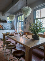 Dining table with candlesticks and small Christmas tree in the kitchen