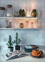 Kitchen shelf with lanterns, worktop with cake and baking book