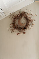 Autumn wreath of dried twigs and leaves on a beige wall