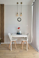 Minimalist dining area with white furniture and pendant lights
