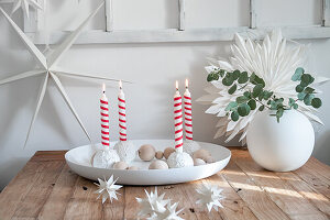 Advent wreath with red and white striped candles and paper stars as Christmas table decorations