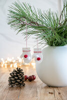 White vase with fir branches and glove Christmas decoration