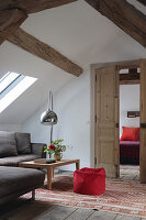 Attic living room with arched light and red pouf