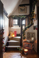 Historic wooden staircase decorated with Christmas lights and presents