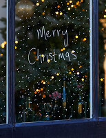 Window decorated for Christmas with "Merry Christmas" lettering