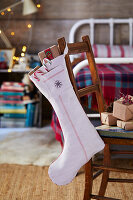 Christmas stocking with presents on a wooden chair in the bedroom