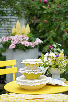 Summery garden table with yellow bowls and flower arrangement