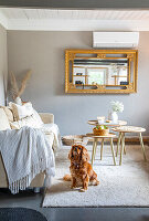 Living room with golden mirror and dog on carpet