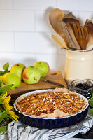 Apple tart with almonds on a chequered cloth in the kitchen
