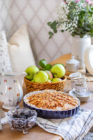 Apple pie on a laid table with flower arrangement