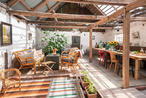Rustic orangery with rattan furniture and dining table