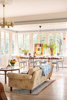 Open-plan living room with large windows, patterned sofa and wooden table