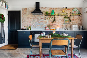 Küche mit Backsteinwand, dunkelblauen Fronten und weihnachtlicher Dekoration