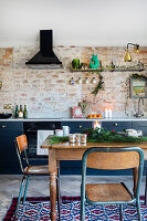 Weihnachtlich dekorierte Küche mit Backsteinwand und rustikalen Holzmöbeln