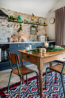 Rustikale Küche mit Holztisch, Backsteinwand und buntem Teppich