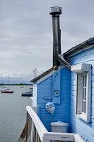 Blue-painted house with chimney on the waterfront