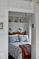 Maritime bedroom with wooden double bed and sailboat motifs