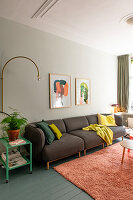 Living room with brown sofa, colourful cushions and artwork on the wall