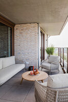 Modern rattan balcony furniture with wooden table on a tiled balcony