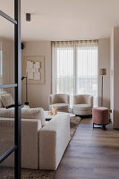 Modern living room with cream-coloured armchairs and wooden floor
