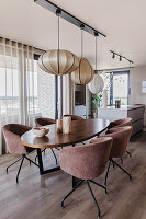 Dining room with oval wooden table and pink velvet chairs