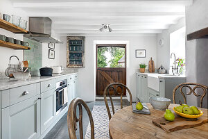 Country-style kitchen with dining area and light blue cupboards