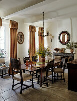 Rustikales Esszimmer mit antiken Möbeln, Vorhängen und Kamin