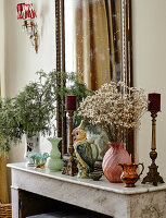 Kaminsims mit Spiegel und dekorativen Vasen und Kerzenhaltern