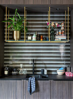 Modern kitchen unit with open brass shelves