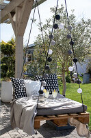 Terrace with floating pallet sofa and fairy lights