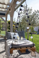 Floating pallet bed with fairy lights on the terrace