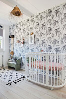 Brightly furnished baby room with floral wallpaper and white cot