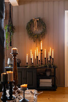 Candlestick with burning candles on a chest of drawers in the living room