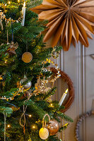 Weihnachtlich geschmückter Tannenbaum mit goldenen Ornamenten und Lichterkette