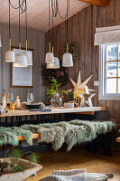 Essbereich mit Holztisch, Holzbank, Fellüberwürfen und stilvoller Weihnachtsdeko