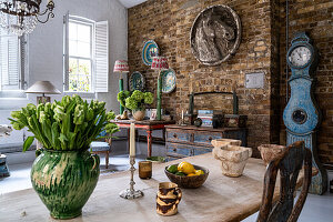 Esszimmer mit Backsteinwand und antiken Möbeln