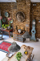 Offener Essbereich mit Backsteinwänden, antiken Möbeln und Standuhr