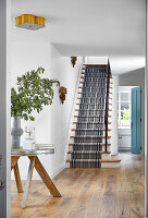 Entrance area with wooden staircase and striped carpet runner