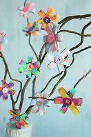 Colourful DIY flowers made from painted cardboard rolls on a decorative branch