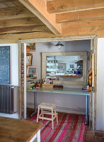 Alcove with desk, large mirror and wooden beamed ceiling