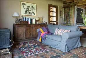 Rustic living room with blue sofa and patterned carpet