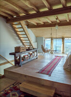 Attic room with wooden beamed ceiling and rustic bookshelf