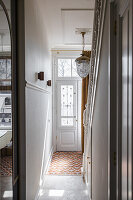 Bright entrance area with decorative chandelier and patterned tiled floor