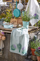 Türkisfarbene Küchenutensilien mit bedrucktem Geschirrtuch draußen im Freien