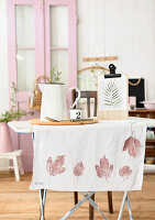 Table runner with leaf print on small indoor table