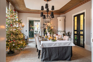 Festlich gedeckter Esstisch mit Weihnachtsbaum im eleganten Esszimmer