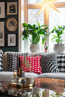 Wohnzimmer mit gemusterten Zierkissen und rundem Couchtisch