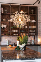 Küche mit Weinglas-Kronleuchter und Marmor-Arbeitsplatte